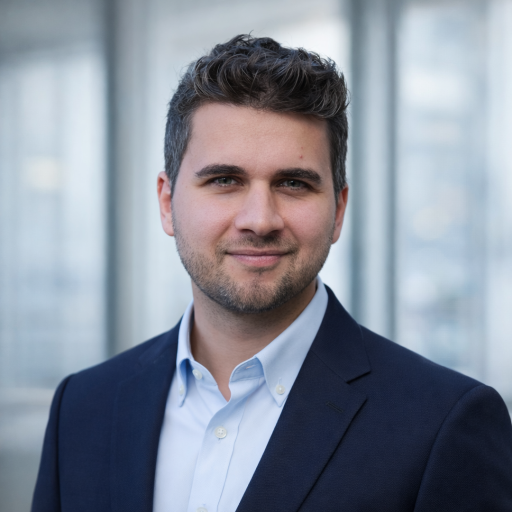 Portrait professionnel du fondateur de Neokasa, en blazer bleu marine, dans un cadre de bureau moderne.